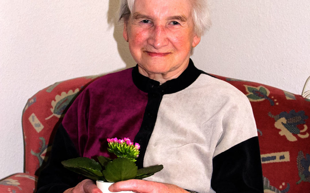 Foto: Frau Merk mit Blume im Sessel